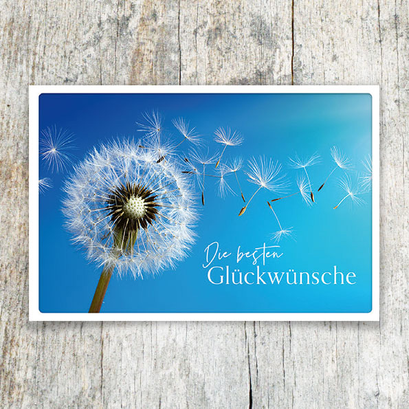Vergrößerte Abbildung Glückwunschkarten mit Pusteblume, fliegenden Samen, blauem Himmel und dem weißen Schriftzug Die besten Glückwünsche