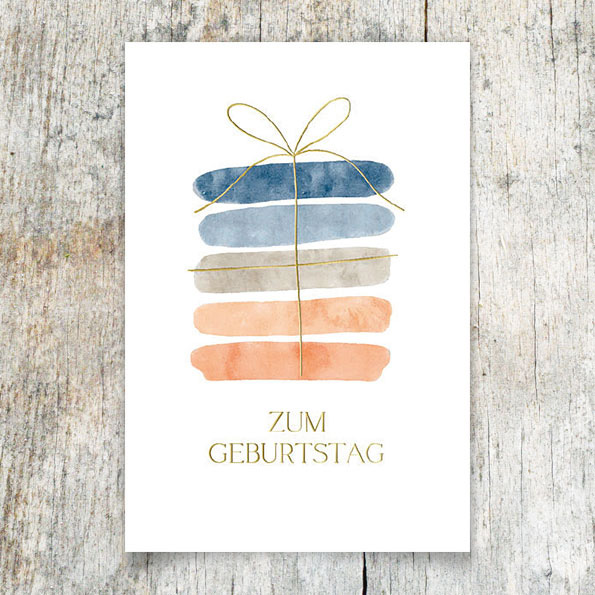 Vergrößerte Abbildung Geburtstagskarte mit Aquarellmotiv und goldener Folienprägung 'Zum Geburtstag' sowie Geschenk mit goldener Schleife