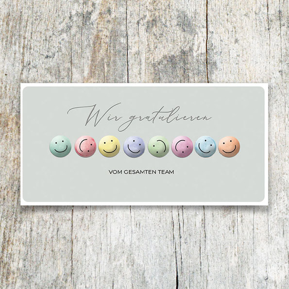 Vergrößerte Abbildung Firmen-Glückwunschkarte DIN lang mit bunten Smileys in Blindprägung und silbernem Schriftzug 'Wir gratulieren – Vom gesamten Team'